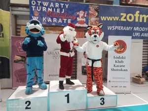 Kot Prewencjusz, maskotka Łódzkiego Klubu Karate Shotokan oraz osoba przebrana za świętego Mikołaja na podium.