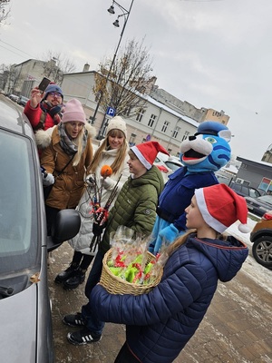 Dzieci oraz policjanci i Kot Prewencjusz stoją przy aucie kontrolowanego kierowcy.