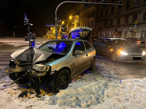 Rozbite auto zatrzymanego, w tle nieoznakowany radiowóz policji.