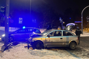 Rozbite auto zatrzymanego, w tle nieoznakowany radiowóz policji.
