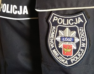 Kurtka policyjna z naszywką Komendy Miejskiej Policji w Łodzi.