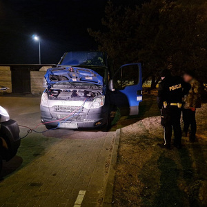 Policjant wraz z właścicielem pojazdu, w którego uruchamianiu pomagał patrol ruchu drogowego.