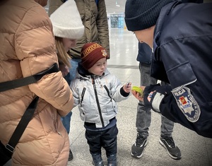 Policjantka wręcza odblask dziecku.
