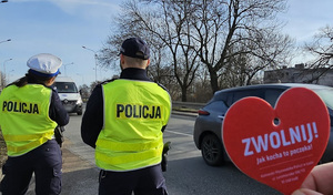 Policjanci w trakcie akcji rozdawania serduszek z napisem Zwolnij jak kocha to poczeka.