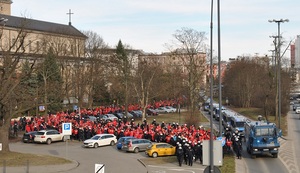 Policjanci zabezpieczają przemarsz kibiców Widzewa Łódź na mecz derbowy.