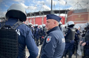 I Zastępca Komendanta Miejskiego Policji w Łodzi rozmawia z funkcjonariuszem o zabezpieczeniu przemarszu kibiców.