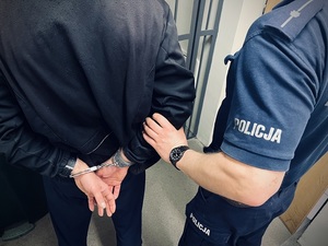 Zatrzymany prowadzony przez policjanta.