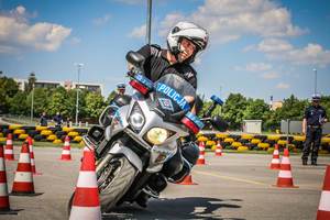 Funkcjonariusz ruchu drogowego w trakcie ćwiczenia jazdy motocyklem służbowym.