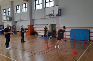 uczestnik konkursu podczas pokonywania toru przeszkód biega między tyczkami.
