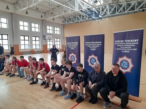 Uczestnicy konkursu wraz z opiekunami na tle roll upów z logo sponsora nagród.