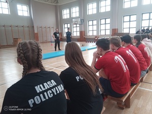 Uczestnicy słuchają zasad konkursu przekazywanych przez policjantów.