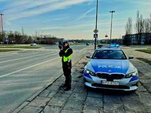 Policjantka z Wydziału Ruchu Drogowego Komendy Miejskiej Policji w Łodzi mierzy prędkość przed przejściem dla pieszych.