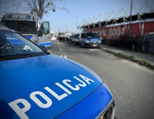 Radiowozy policyjne na zabezpieczeniu spotkania piłkarskiego.