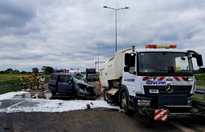 Roztrzaskane pojazdy i strażacy w trakcie akcji.