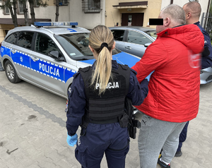 Umundurowani policjanci prowadzą zatrzymanego.