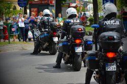 Trzy motocykle policyjne, na których siedzą umundurowani funkcjonariusze.