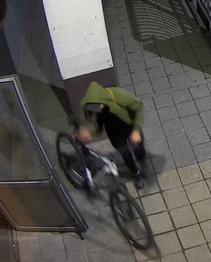 Sprawca kradzieży stoi obok roweru.