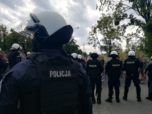 Policjanci zabezpieczają przemarsz kibiców przyjezdnych na stadion.