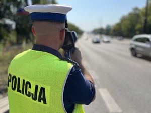 Policjant w trakcie pomiaru prędkości.