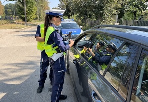 Umundurowani policjanci ruchu drogowego w trakcie kontroli pojazdu.