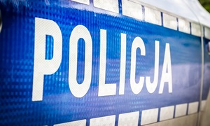 Napis policja na drzwiach oznakowanego radiowozu.