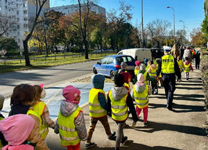 Wspólny spacer przedszkolaków z policjantką, na którym poznają zasady ruchu drogowego.