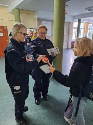 Policjantki rozdają dzieciom odblaski.