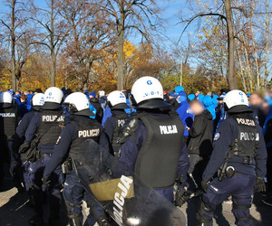 Policjanci zabezpieczają przemarsz kibiców przyjezdnych na stadion przy alei Unii.