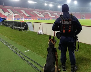 Policyjny przewodnik psa ze swoim podopiecznym na stadionie.