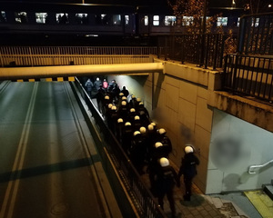 Policjanci zabezpieczają przejście kibiców na dworzec kolejowy.