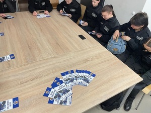 Młodzież zapoznaje się z ulotkami dotyczącymi procesu rekrutacji do policji.