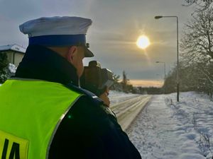 Policjant kontrolujący prędkość pojazdów na drodze.