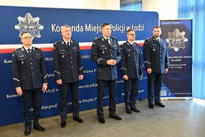 Wspólne zdjęcie Komendanta Miejskiego Policji w Łodzi młodszego inspektora Mariusza Siejki, p.o. I Zastępcy Komendanta Miejskiego Policji w Łodzi podinspektora Jakuba Kowalczyka, p.o. Zastępcy Komendanta Miejskiego w Łodzi młodszego inspektora Kamila Szczęsnego oraz p.o. Zastępcy Komendanta Miejskiego Policji w Łodzi Roberta Ludwikowskiego i przemawiającego Zastępcy Komendanta Wojewódzkiego Policji w Łodzi młodszego inspektora Adama Jurka.