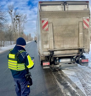 Policjant Wydziału Ruchu Drogowego podczas kontroli auta dostawczego.