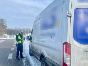 Policjant Wydziału Ruchu Drogowego podczas kontroli drogowej busa.