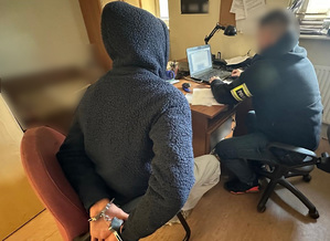 Policjant w trakcie czynności z zatrzymanym mężczyzną.