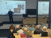 Policjant w trakcie prezentacji na spotkaniu z seniorami.