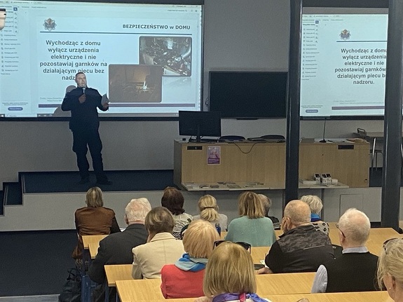 Policjant w trakcie prezentacji na spotkaniu z seniorami.