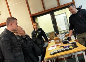 Rozmowa licealistów z policyjnym instruktorem strzelectwa.