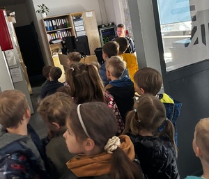 Przedszkolaki rozmawiają z Dyżurnym jednostki policji.