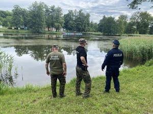 Policjant i inspektorzy ze Straży Rybackiej w trakcie kontroli.