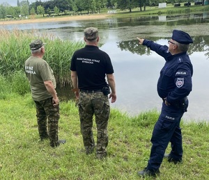 Policjant i inspektorzy ze Straży Rybackiej podczas kontroli.