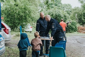 Policjanci rozmawiają z uczestnikami pikniku.