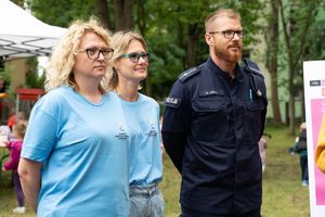 Policjant stoi obok pracownic MOPS w Łodzi.