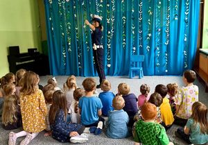 Policjantka prezentuje sygnały jakie daje kierowcom policjant ruchu drogowego