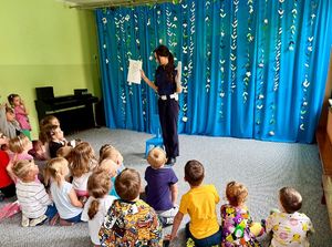 Policjantka prezentuje przedszkolakom malowanki.