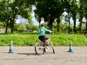 Chłopiec na rowerze w trakcie pokonywania slalomu.