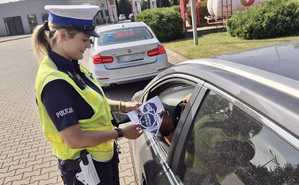 Policjantka wręcza materiały partnera akcji &quot;Zwolnij, mistrzu&quot;.