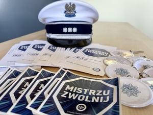 Materiały promocyjne akcji &quot;Zwolnij, mistrzu&quot;, w te czapka policyjna.
