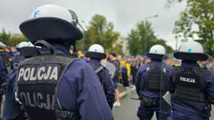 Policjanci z Oddziału Prewencji Policji w Łodzi zabezpieczają przejście kibiców na stadion.